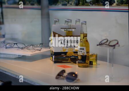Berlin, Deutschland. 21. März 2020: In einem Schaufenster eines Optikers in Berlin-Schönenberg sind neben der regulären Anzeige mehrere Flaschen Corona-Bier zu sehen. Der Regierende Bürgermeister von Berlin, Michael Mueller (SPD), bereitet sich darauf vor, die Bewegungen der Anwohner auf die Eindämmung der tödlichen Coronavirus-Pandemie zu beschränken. Öffentliche Veranstaltungsorte wie Bars, Clubs, Museen, Kinos, Schulen, Kindertagesstätten und Universitäten sind bereits geschlossen. Viele Unternehmen greifen für ihre Mitarbeiter auf Heimarbeit zurück. Und die Reise über die Grenze in die meisten Nachbarländer ist stark eingeschränkt. (Bild: © Jan Scheune Stockfoto
