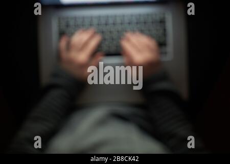 Hacker in der Kapuze, die mit dem Schreiben von Text in der Dunkelkammer arbeiten. Stockfoto