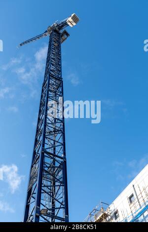 Low-Angle schoss im März 2020 in Glasgow City Centre, Schottland, einen hohen Turmkran gegen einen blauen Himmel Stockfoto