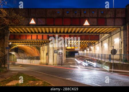 Vyne Road/Chapel Hill Eisenbahnbrücke E1/135A auf der Eisenbahnlinie BML1 in Basingstoke zur Nachtzeit. RBE Stahlträger- und Ziegelbogenkonstruktion. Stockfoto