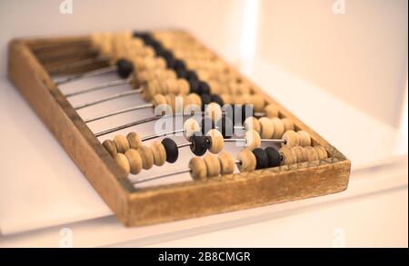 Alte Holzkerben. Nahaufnahme Abakus . Abacus auf hellem und braunem Hintergrund. Sparkonzept, Zählung. Buchhaltungs- und Budgetkonzept. Stockfoto