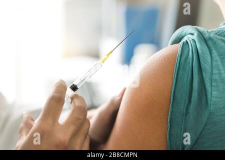 Impfstoff oder Grippe in Injektionsnadel aufgenommen. Arzt, der mit dem Arm des Patienten arbeitet. Arzt oder Pfleger, der Impfung und Immunität gegen Viren oder Influenza verabreicht. Stockfoto