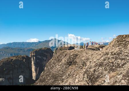 Kerkyra, Insel Korfu, Griechenland - 4. Oktober 2019: Auf einem großen Felsen wird eine Touristengruppe fotografiert. Blick auf die wunderschöne Landschaft der grünen Berge mit Stockfoto