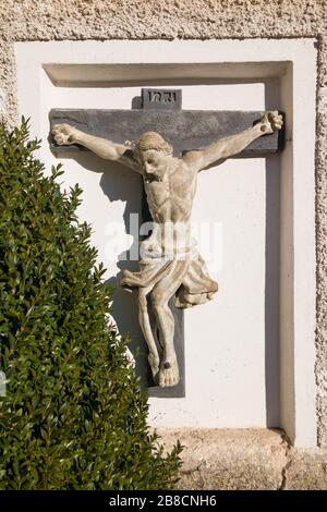 Kruzifix (Jesus am Kreuz) an der Wand der katholischen Pfarrkirche Maria Himmelfahrt (Maria am Berg) in Hallstatt, Österreich Stockfoto