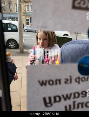 Ilkley, Yorkshire, Großbritannien. März 2020. Frances Tidswell-Thompson (12) genießen einen Snack vor Greggs. Die Kette kann aufgrund des Coronavirus nicht mehr bei Kunden essen. Credit: West Yorkshire Images/Alamy Live News Stockfoto