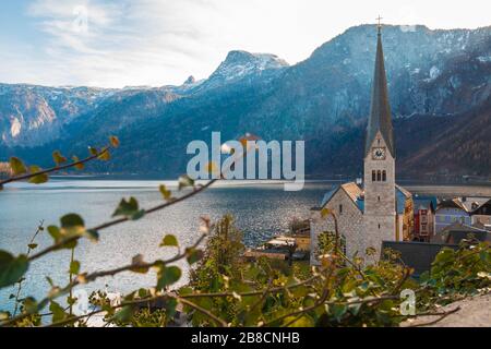 Blick auf die berühmte österreichische Stadt Hallstatt, neogotische evangelische Kirche am Hallstaetter See, umgeben von Bergen an einem sonnigen Herbsttag. Stockfoto