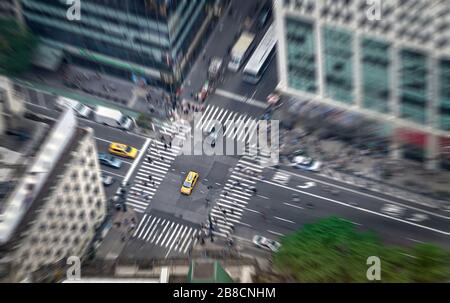 New York City Street voller Taxis, Autos und Fußgänger. Gelbe Kabine im Fokus. Geschäftige Innenstadt von NYC. Menschenmenge, die sich über die Querswalks queren. Stau. Stockfoto