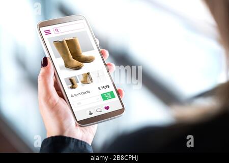 Einkäufe von weiblichen Kunden im Online-Modegeschäft mit Handy. Frau kauft Schuhe oder Stiefel mit Smartphone. Internetverkauf auf der Website im Handy. Stockfoto