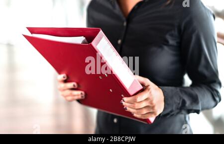 Professionelle Geschäftsfrau mit Ordner voller Papierdokumente. Rechtsanwalt, Rechtsberater, Büroangestellter oder Betriebsleiter mit Binder. Stockfoto