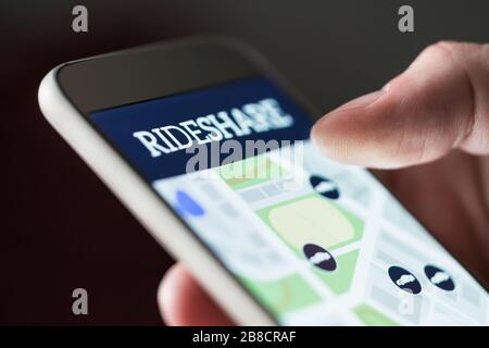 Mit der App "Teilen" auf dem Smartphone. Mann mit Rideshare Taxi-Anwendung. Online-Carpool oder Carsharing-Service auf dem Handy. Stockfoto