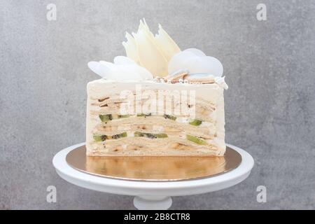 Scheibe Vanilleschwammkuchen mit frischen Bananen und Kiwi innen auf grauem Hintergrund Stockfoto