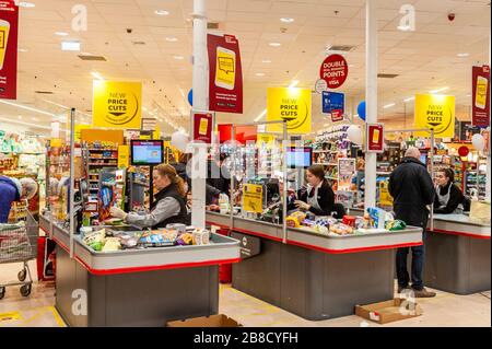 Bandon, West Cork, Irland. März 2020. SUPERVALU hat an seinen Checkouts Schutzgitter aus Kunststoff installiert, um die Richtlinien zur sozialen Distanzierung der Regierung aufgrund des COVID-19-Virus zu befolgen. Die Bildschirme sollen die Kassenmitarbeiter schützen, die auch mit Einwegschürzen ausgestattet wurden. Kredit: Andy Gibson/Alamy Live News Stockfoto