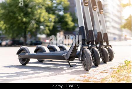 Elektrische Kick Roller in der Stadt. E Fahrzeug zur Miete. Städtisches modernes Verkehrs- und Technologiekonzept. Stockfoto