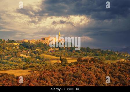 Blick auf die toskanische Mittelalterstadt Pienza mit bunten Bäumen und Feldern bei Sonnenuntergang Stockfoto