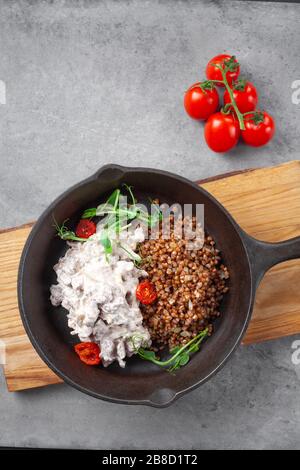 Rinderstroganoff in Sahne und Buchweizen und Kirschtomaten in Pfanne Stockfoto
