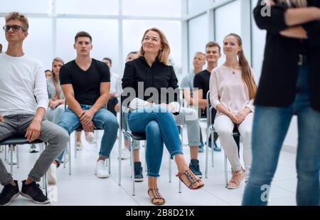 Gruppe verschiedener Jugendlicher, die in einem Konferenzraum sitzen Stockfoto