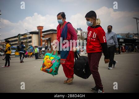 Mutter und Sohn, die während der Pandemie des Corona-Virus ihre Habseligkeiten in den Buspark tragen.Kathmandus neuer Buspark ist überfüllt, nachdem die Regierung beschlossen hat, Langfahrwagen inmitten von Covid-19-Ängsten zu stoppen, die vom 23. März bis 31. März wirksam sind. In den letzten drei Tagen verließen mehr als 500.000 das Kapital. Stockfoto