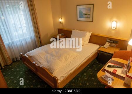 Standard Bett (Doppelbett, aber als Einzelzimmer verkauft) im Hotel Chalét zum Kurfürst, Oberschleißheim, München, Bayern, Deutschland. Stockfoto