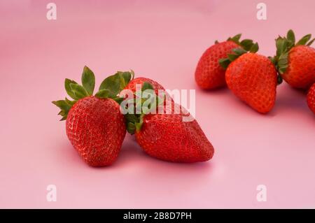 Frische saftige Erdbeeren auf rosa Backround Stockfoto