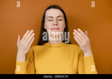 Entspannte Brünette Frau genießen guten Geruch oder angenehmen Duft, ruhig achtsam junge Frau unter tiefen Atem fühlen keine Stress frei Einatmen frisch Stockfoto