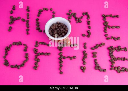 Heimbüro aus Kaffeebohnen auf pinkfarbenem Hintergrund Stockfoto