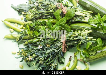 Grünes Gemüse und Kräuter auf Minzpastell Stockfoto