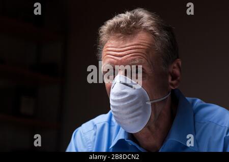 Reifer Arzt oder Patient mit einer Schutzmaske, die besorgt aussieht Stockfoto
