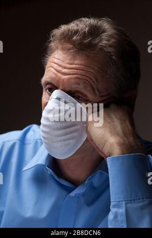 Müde Arzt mit Schutzmaske, die nachdenklich aussieht Stockfoto