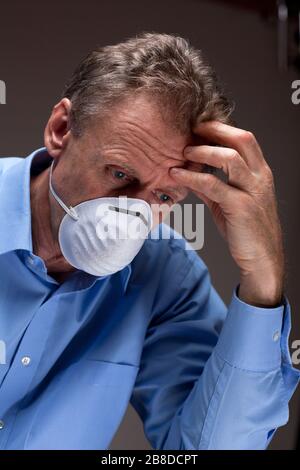 Nachdenklicher besorgter Arzt mit medizinischer Maske in einem Krankenhaus Stockfoto