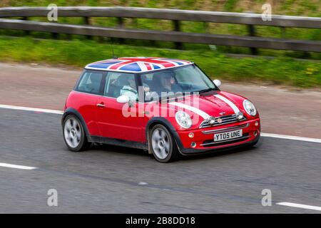 2005 Custom Red White Mini Cooper; UK Vehicular Traffic, Straßentransport, Union Jack Dachgrafik Fahrzeuge, maßgeschneiderte Limousinen, Fahrzeugfahren, Straßen und Motoren, Motorfahren in südlicher Richtung auf der Autobahn M61 Stockfoto