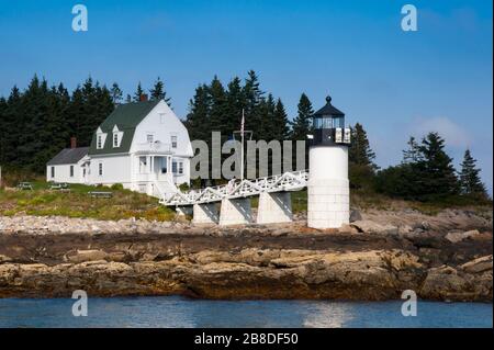 Hafenblick auf den Marshall Point Lighthouse in Port Clyde in Maine entlang des felsigen Ufers. Das Gebiet zieht eine Künstlergemeinschaft an. Stockfoto