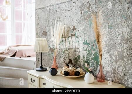 skandinavische Dekoration auf Beton Hintergrund.getrocknete Blumen und Vegetation in einem modernen Interieur. Inneneinrichtung im Öko-Stil mit Grün.Home Stockfoto