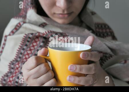 Kranke elegante Frau, die eine Tasse Tee hält Stockfoto