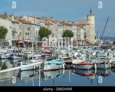 Vieux Port aka alten Hafen in einer mediterranen Stadt La Ciotat in Südfrankreich mit vielen angedockten kleinen Booten und der Hauptkirche der Stadt Stockfoto