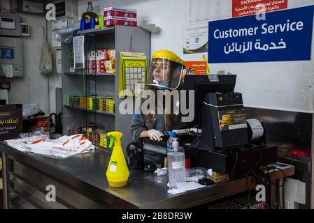 Le Charcutier, Beirut, Libanon. März 2020. Die Mitarbeiter der Supermarkt-Kasse tragen Vollgesicht- und Handschuhe, wenn sie die Einkäufe der Käufer überprüfen. Credit: Elizabeth Fitt/Alamy Live News Stockfoto