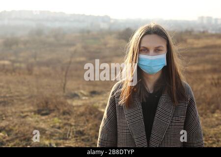 Junge Frau schützt vor Coronavirus im Freien. Covid-19. Stockfoto