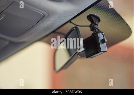 Kleine schwarze Autokamera auf der Windschutzscheibe hinter dem Spiegel Stockfoto