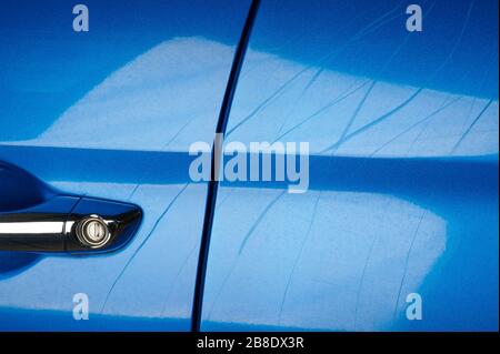 Linien auf blauem Autolack aus Krallen von Tieren Stockfoto