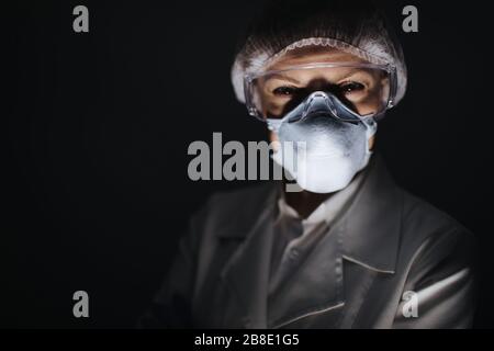 Professioneller weiblicher Arzt in Schutzuniform im Studio Stockfoto