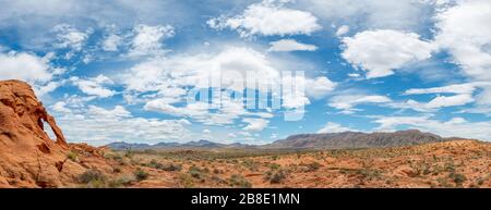 USA, Nevada, Clark County, Gold Butte National Monument. Ein roter Sandsteinbogen an den Mud Hills und ein Panorama auf Tramp Ridge Stockfoto