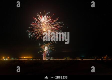 USA, Nevada, Esmerelda County, Hawthorne. Ein Aufbruch des roten Feuerwerks unter einem Sternenhimmel in der Wüstennacht. Stockfoto