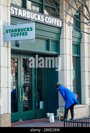 Washington, USA. März 2020. Eine Frau liest ein Schild, in dem angekündigt wird, dass die Schließung des Stores am 21. März 2020 im Fenster eines Starbucks in der M Street in Washington, DC, veröffentlicht wird. Starbucks kündigte heute an, dass die nächsten zwei Wochen nur Café-Geschäfte geschlossen werden und der Drive-Thru-Betrieb weiterhin geöffnet bleiben wird. (Foto von Leigh Vogel/Sipa USA) Kredit: SIPA USA/Alamy Live News Stockfoto