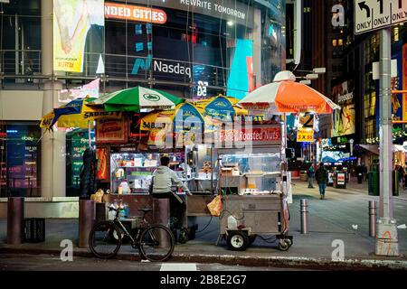 Ein Straßenhändler auf einem menschenleeren Times Square während der Hauptverkehrszeit und die Covid-19-Pandemie in New York City, New York. Stockfoto