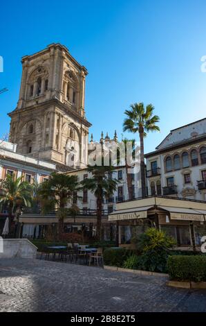 Granada, Spanien - 6. Januar 2017: Restaurant im Freien im Zentrum von Romanilla Plaza mit Kirchturm der Kathedrale von Granada im Hintergrund Stockfoto