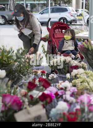 San Francisco, Vereinigte Staaten. März 2020. Eine Frau kauft am Samstag, 21. März 2020, auf dem Farmers Market in der Alemany Street in San Francisco Blumen. Ganz Kalifornien wird angewiesen, sich an Ort und Stelle zu schützen. Foto von Terry Schmitt/UPI Credit: UPI/Alamy Live News Stockfoto