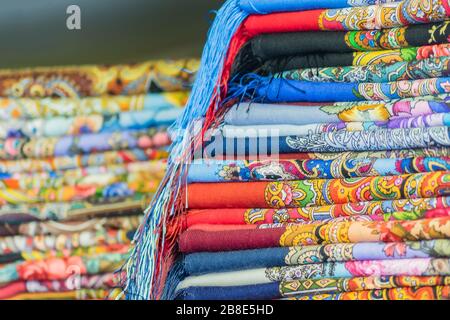 Haufen traditioneller russischer Farbskarren und Kopftücher auf dem Markt. Beliebtes Souvenir aus Russland Stockfoto