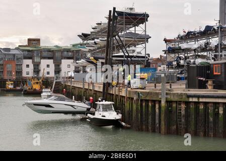 Blick auf die Lagerregale und ein Boot, das vom Wasser gehoben wird, am Camber Dock, Portsmouth, Großbritannien Stockfoto