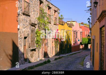 Straßenbelag mit einer Biegung mit typisch farbenfroher Architektur von San Miguel de Allende Mexiko Stockfoto