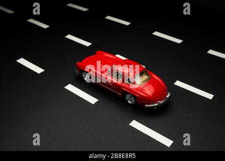 Izmir, Türkei - 28. Juli 2019: Mercedes 300 SL rot gefärbter Spielzeug-Modellwagen auf einer Asphaltstraße mit Fahrspuren. Stockfoto