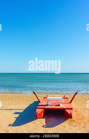 Rotes Rettungsboot am Meer am Strand in Rimini, Italien - Seascape Stockfoto